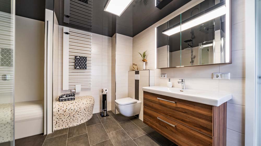 keramisches Duschbad mit Spanndecke in Stendal - Badgröße ca. 9 qm, Umbauzeit ca. 4,5 Wochen, großzügige Dusche mit Sitz, keramischer fugenloser Duschboden mit Duschsitz, satinierte Glastür als Trennung für den Waschmaschinenbereich, schwarze Lackspanndecke mit LED Panel