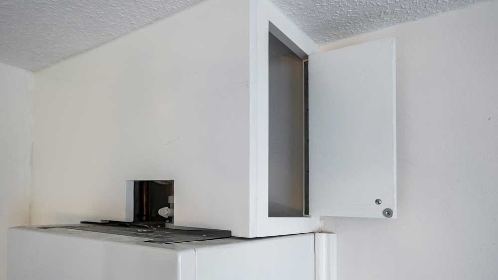 Revisionsöffnung in einer Verkleidung oberhalb des Heizgerätes, seitlich offen