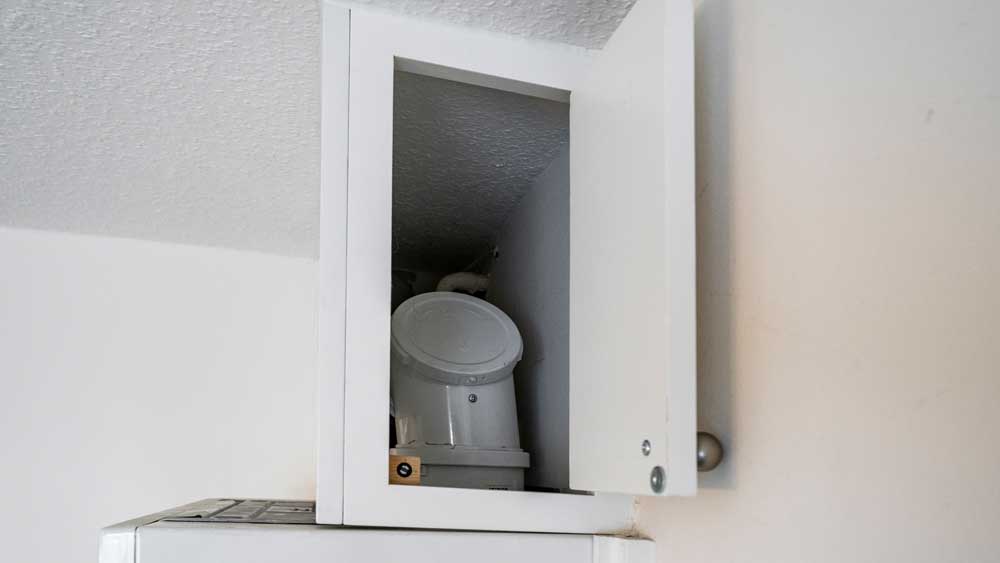 Revisionsöffnung in einer Verkleidung oberhalb des Heizgerätes, seitlich offen, close up