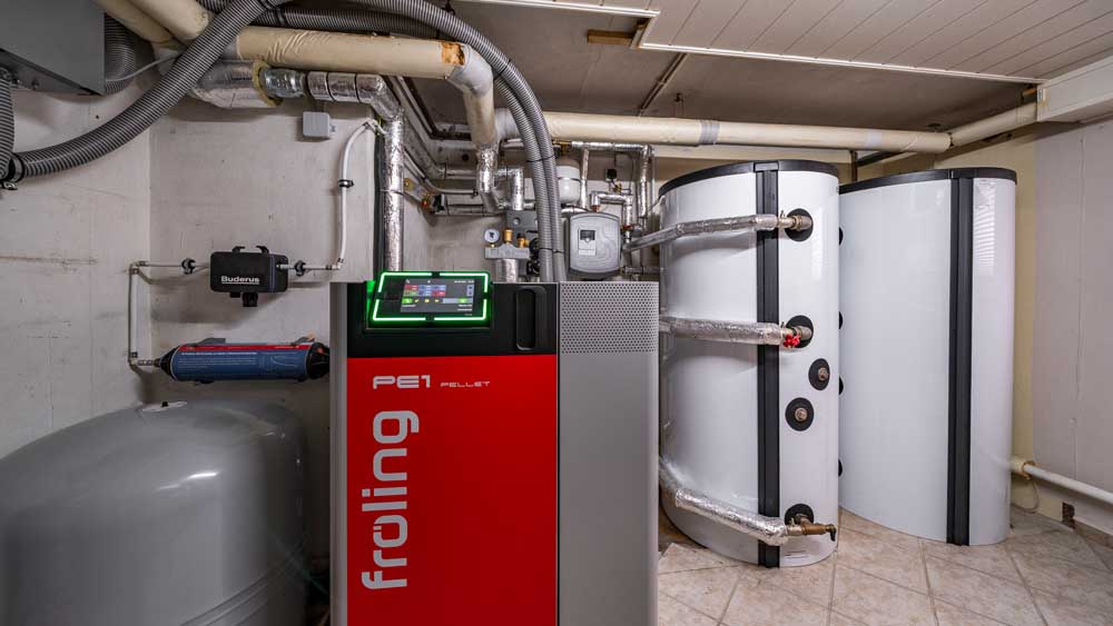 Pelletheizkessel der Firma Fröling mit Ausdehnungsgefäß links und Pufferspeicher rechts im Bild